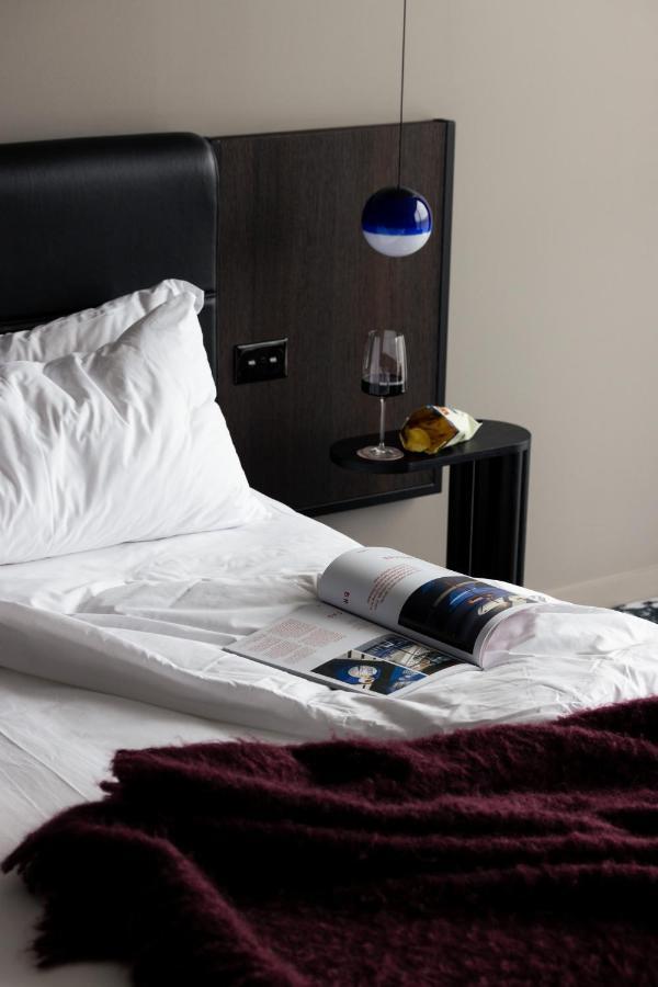 Ebb-Ντούνεντιν Εξωτερικό φωτογραφία A bed with a magazine and a wine bottle